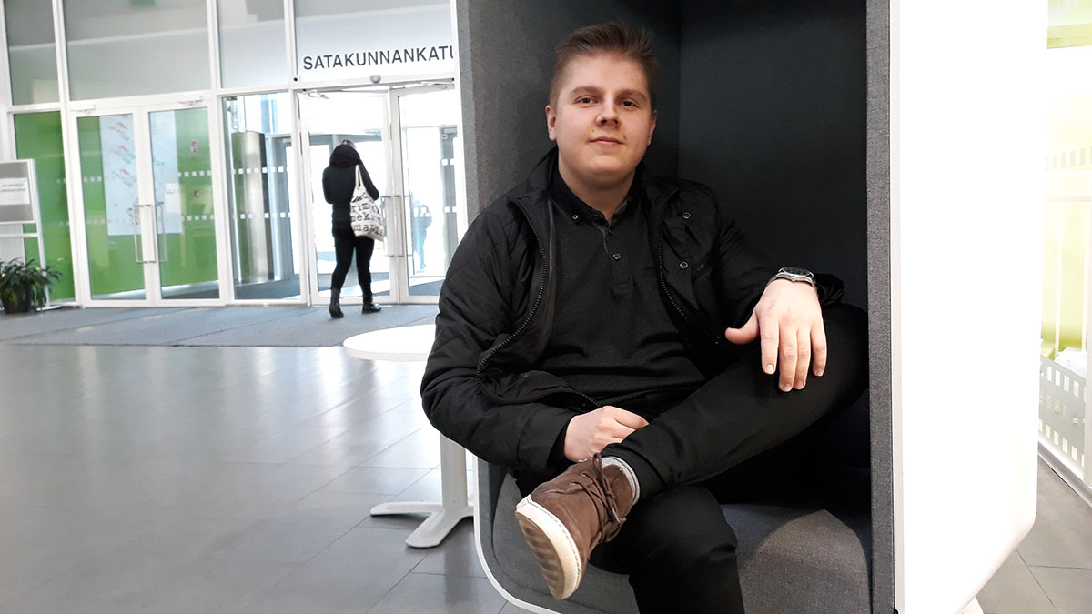 Mies istuu SAMKin Porin kampuksen aulassa