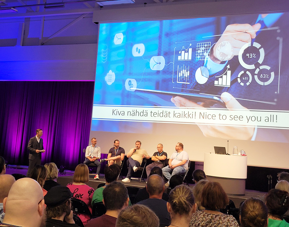 Henkilöstöpäivän paneelikeskustelussa lavalla istuvat panelistit, juontaja seisoo vieressä.