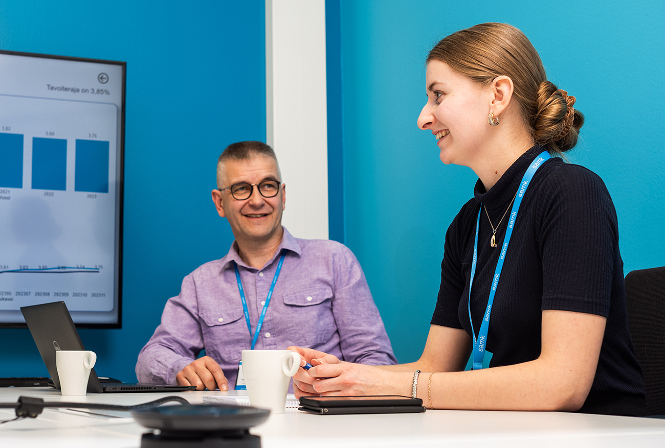 Two people are talking at a computer.