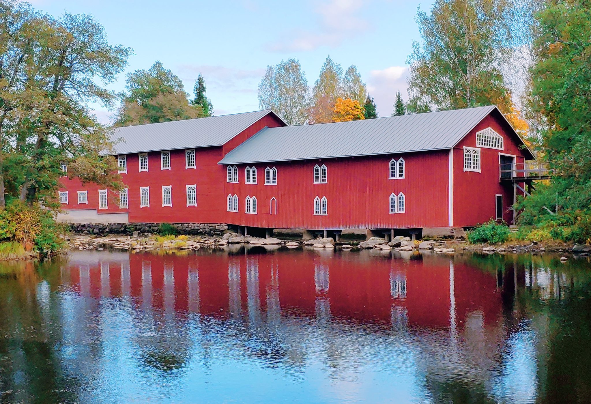 Punainen mökki veden äärellä.