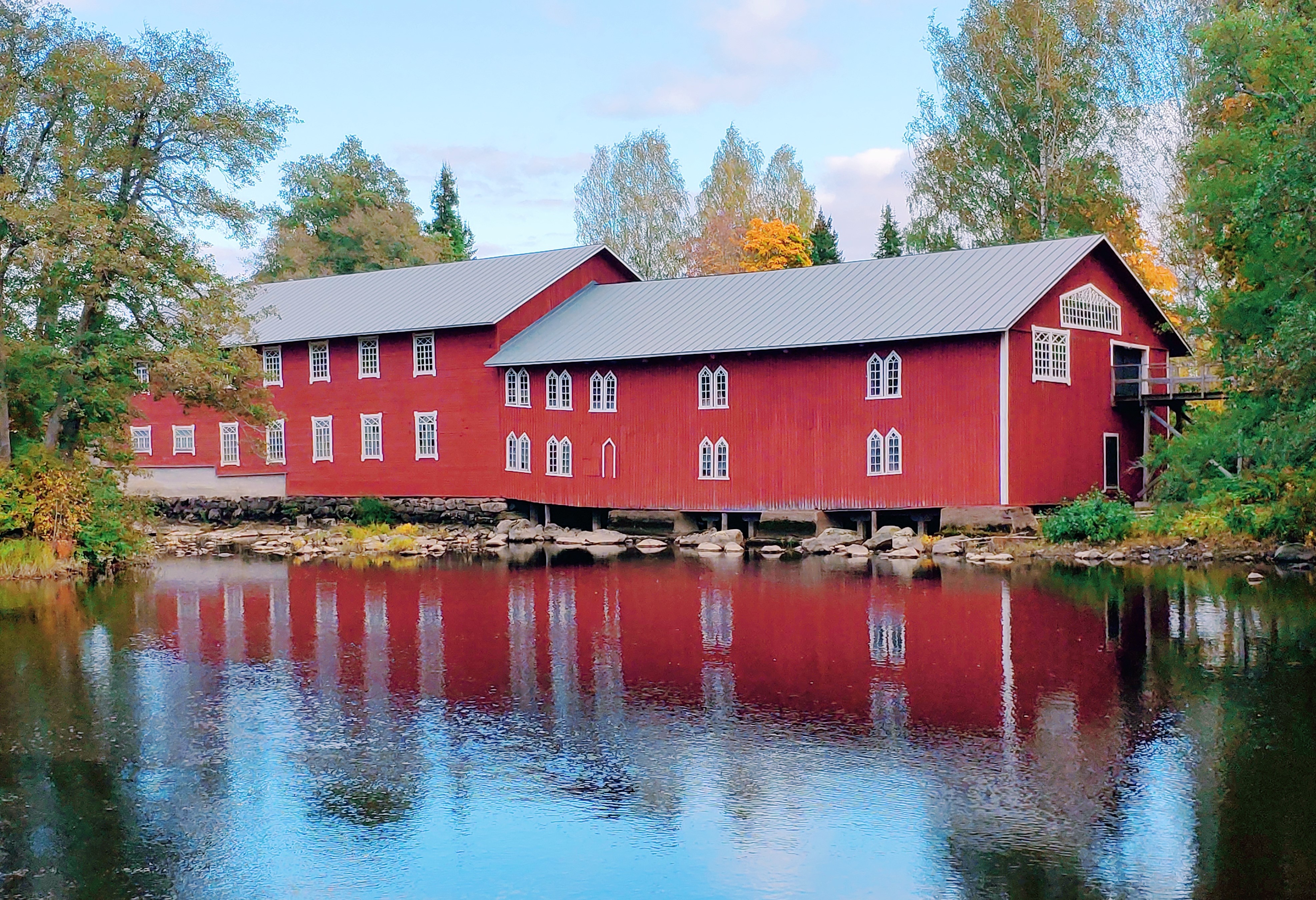 Punainen rakennus veden äärellä.