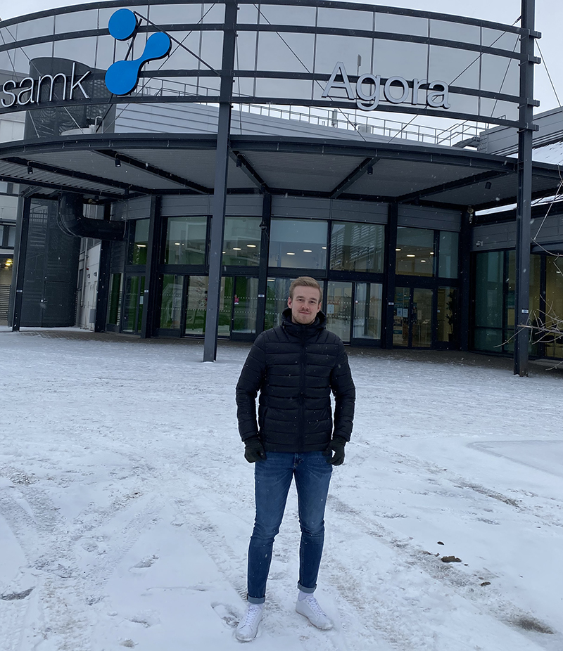 Arttu Lehto seisoo Porin kampuksen kaariovien ulkopuolella.
