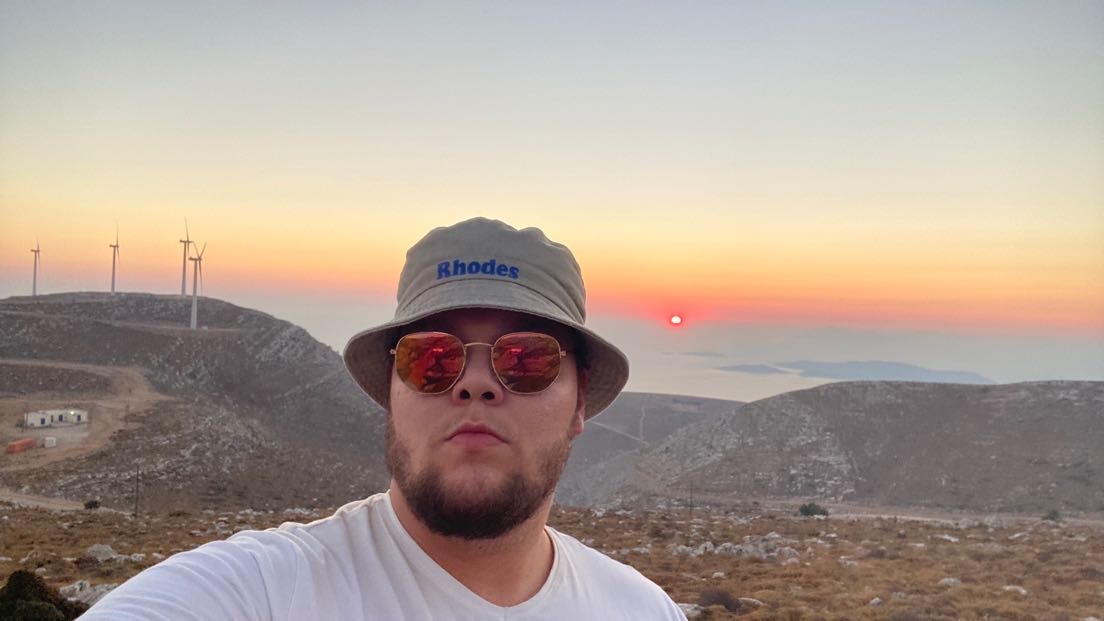 Eino aurinkolasit päässä auringon laskiessa.