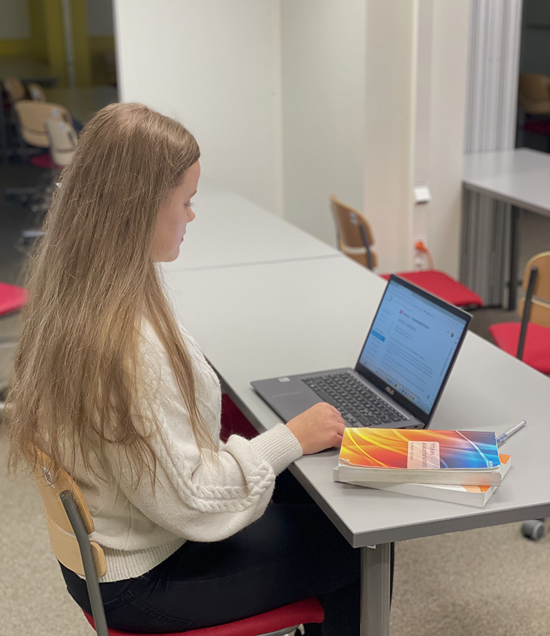 Emma Kivelä kannettavan tietokoneen ääressä.
