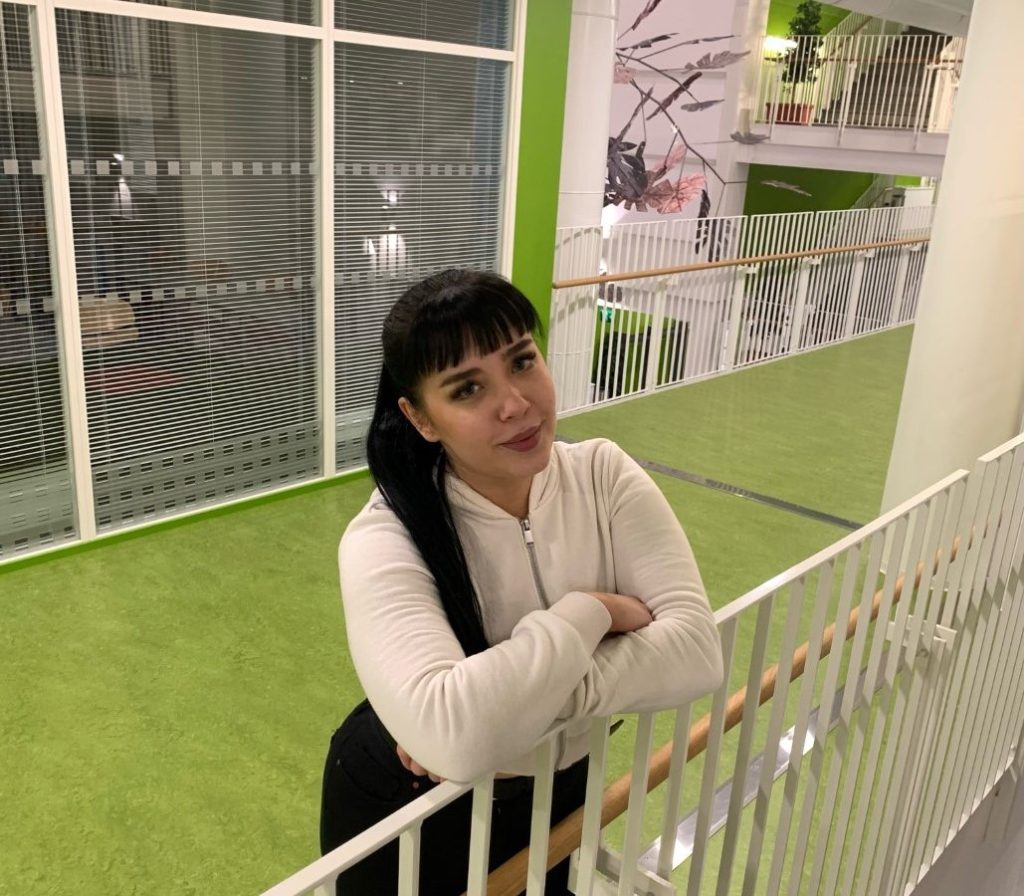 Essi nojaa portaiden kaiteeseen.