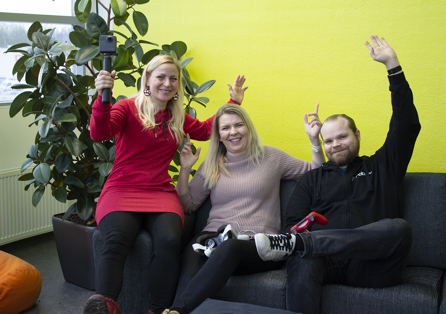 Three people are rooting on the couch.