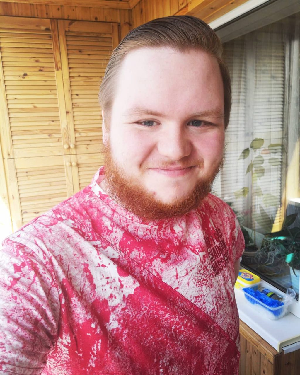 Joakin Heinonen hymyilee puolivartalokuvassa pinkissä paidassa.