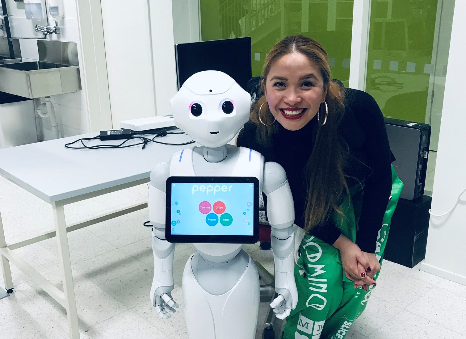Johnnie Mae poseeraa humanoidirobotti Pepperin kanssa.