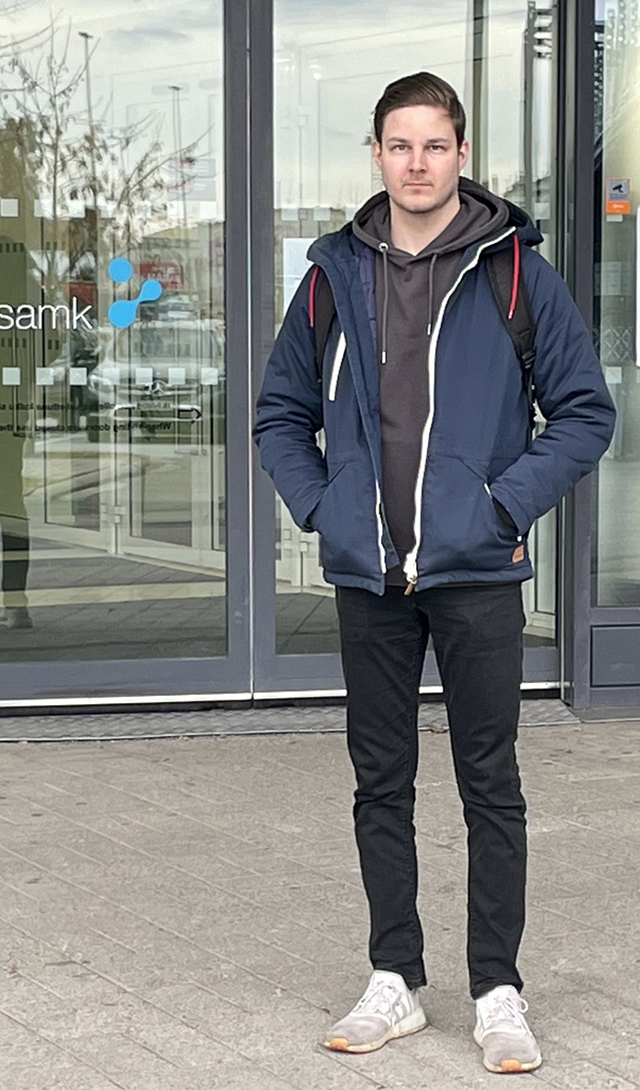 Kristian Palmio seisoo kampuksen etuovella.