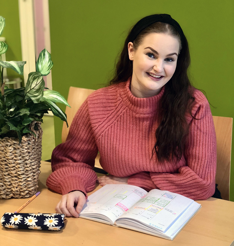 Rosa Leppämäni istuu pöydäm ääressä kirja edessään.