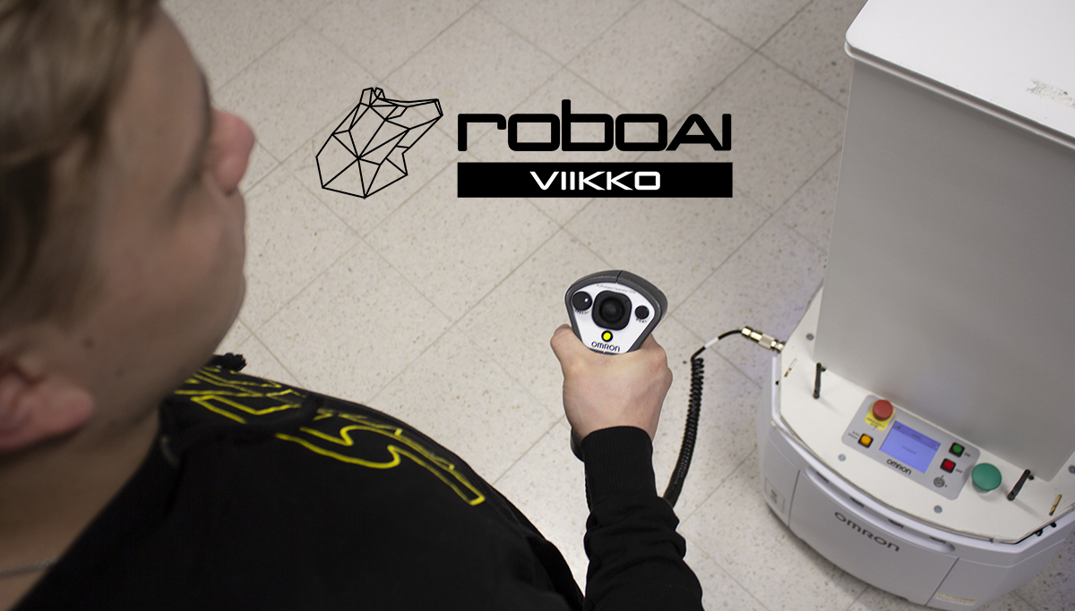 Kuvassa poika, jonka kädessä on mobiilirobotin ohjain.