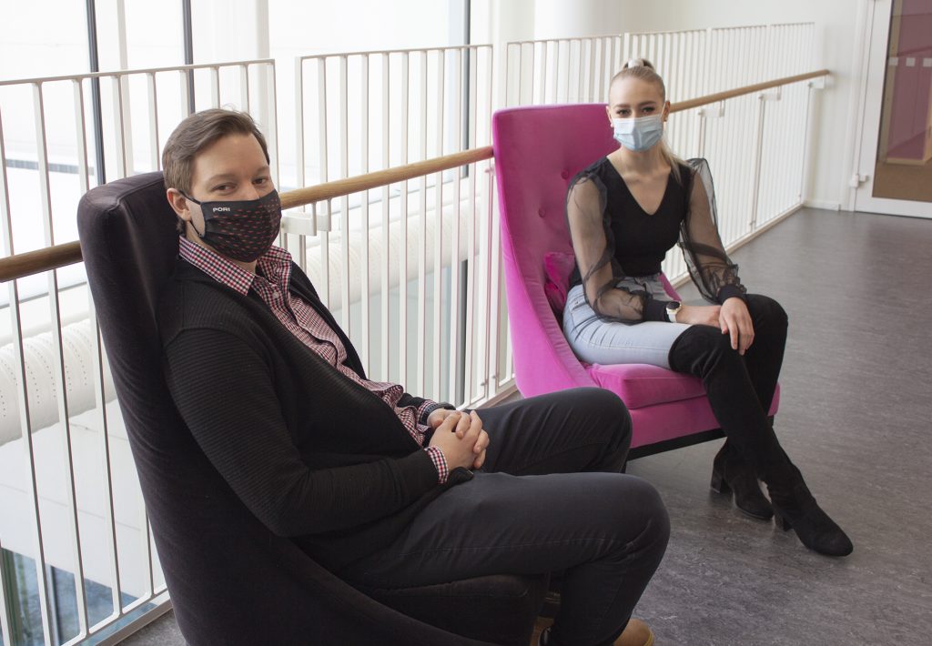 Ollipekka and Vilhemiina are sitting on chairs at the SAMK campus Pori.