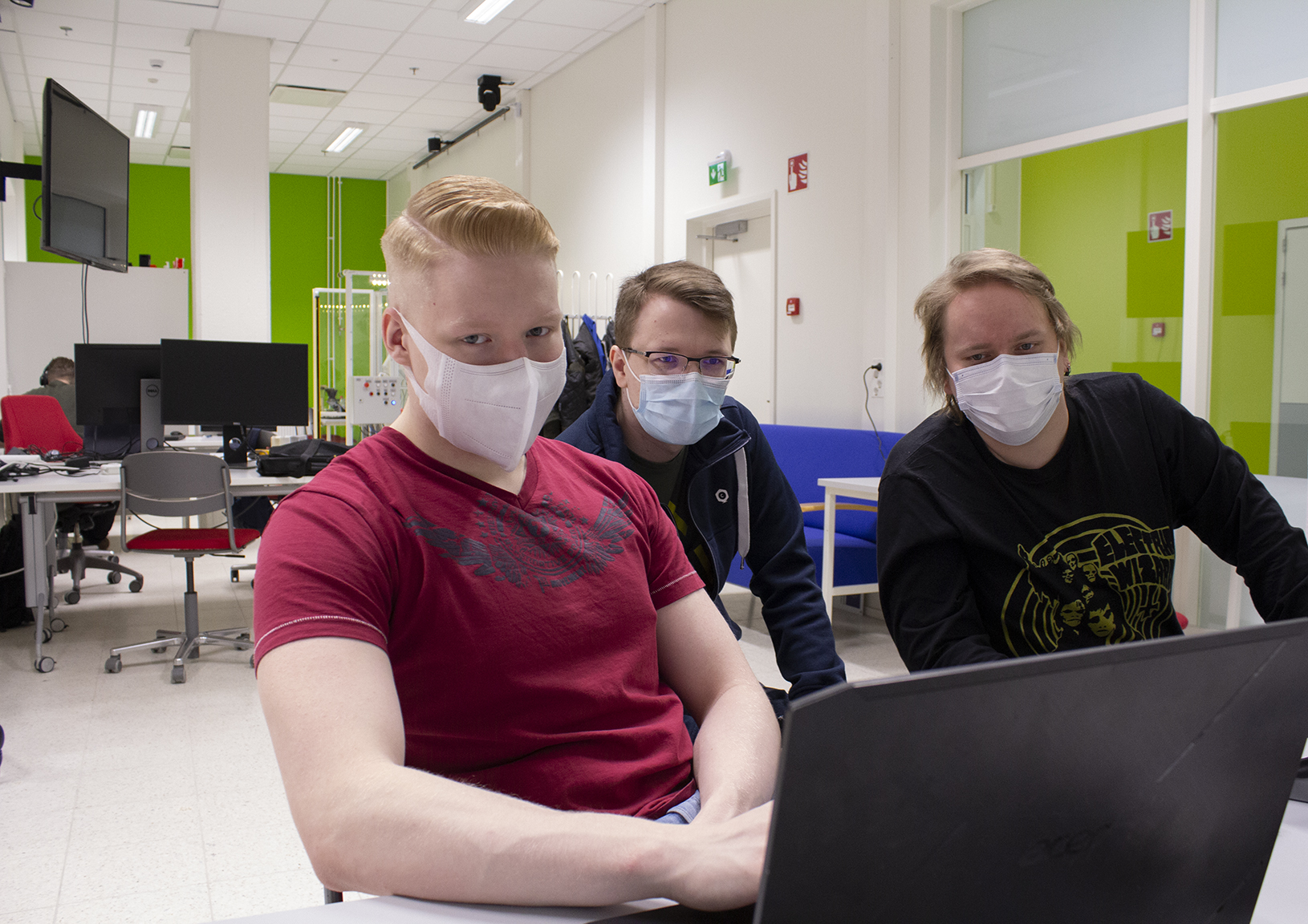 Kolme Robotiikka Akatemian opiskelijaa työskentelee tietokoneella.