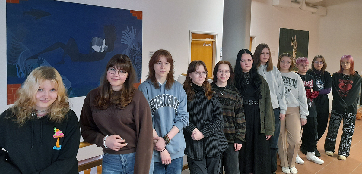 Ryhmälukiolaisia, taustalla taideteoksia