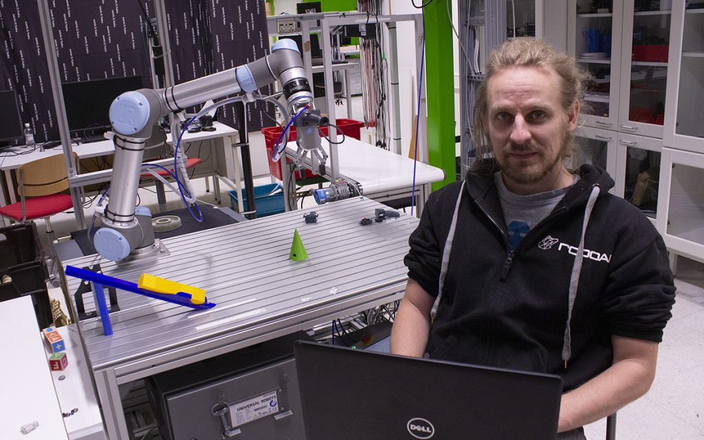 Toni Aaltonen ohjelmoimassa Yumi-käsivarsirobottia.