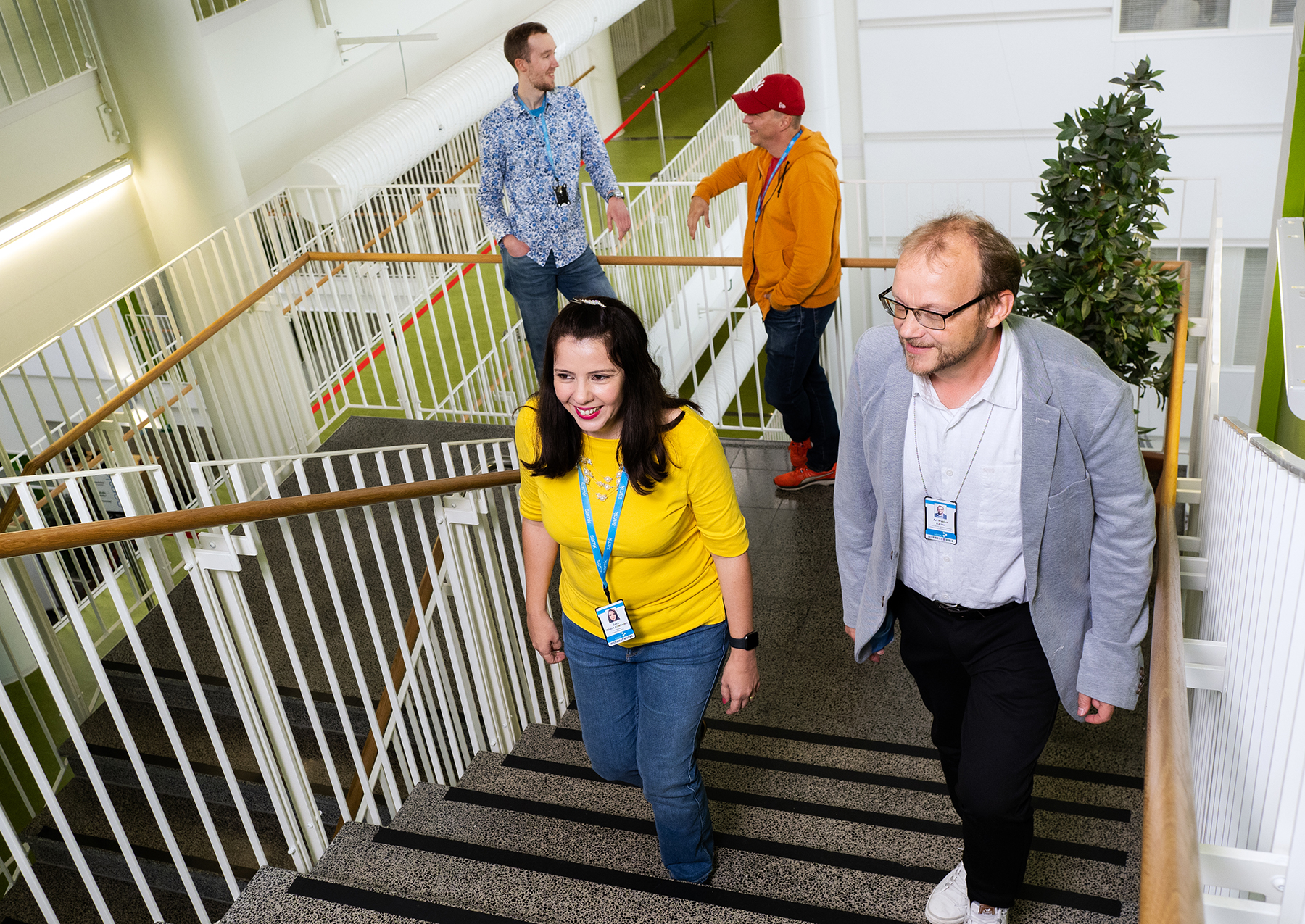 Two people are climbing the stairs and two people are leaning on the railing in the background.