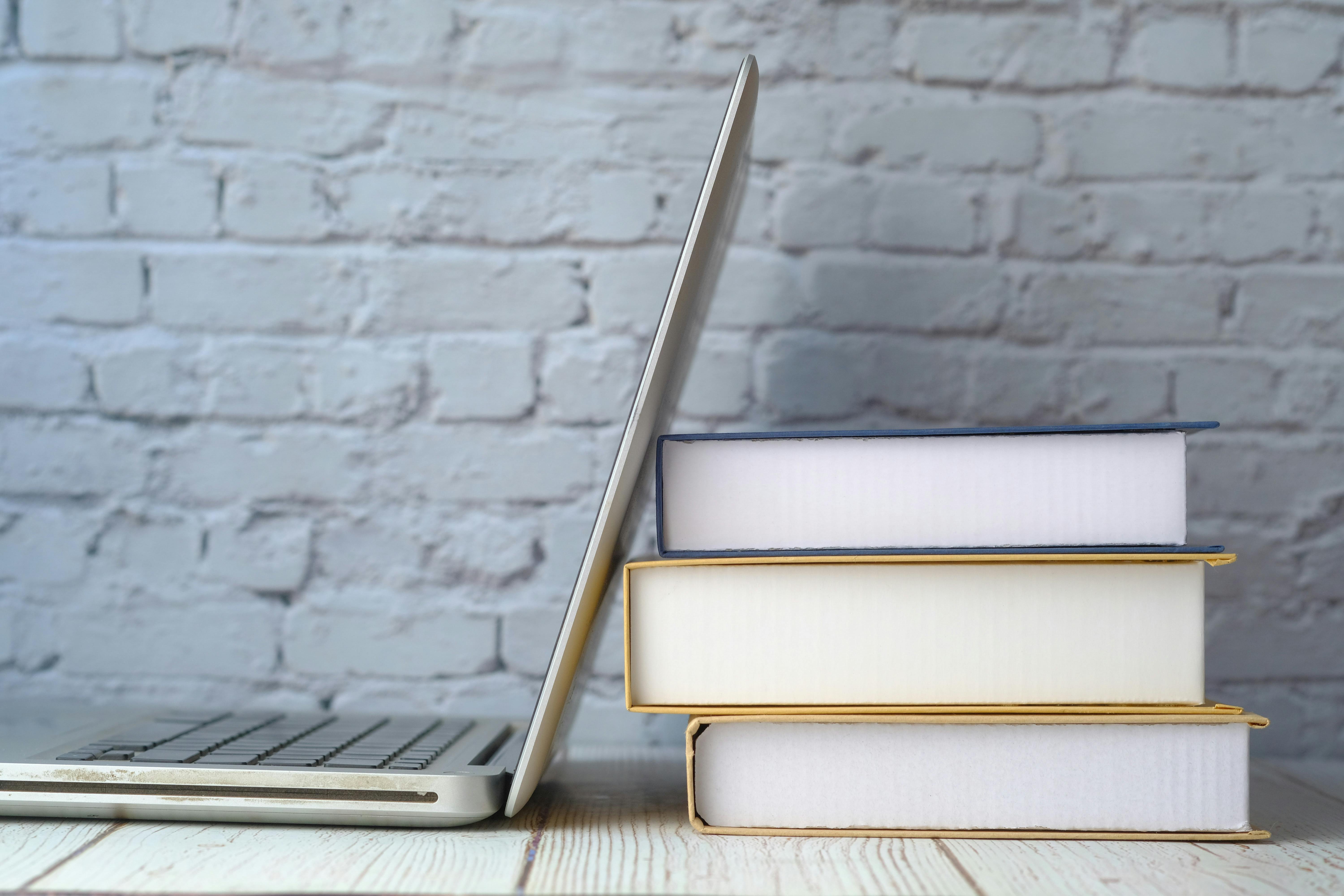 Pile of books and a laptop.