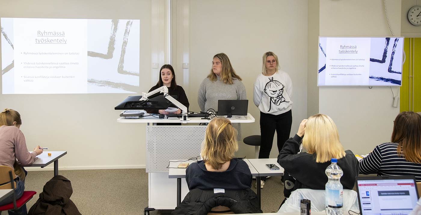 The photo shows tourism students in a group work situation.