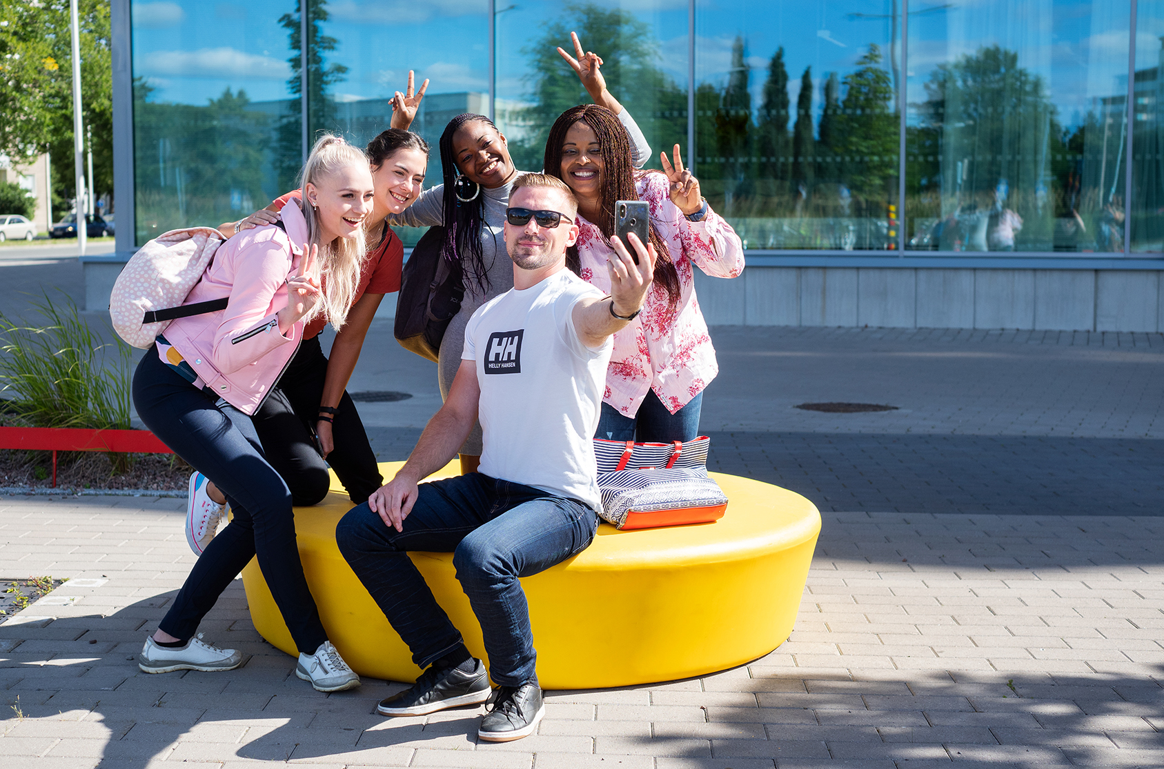 Youth taking selfies outside.