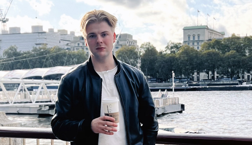 Roope Töykkälä seisoo sillalla kahvikuppi kädessä.