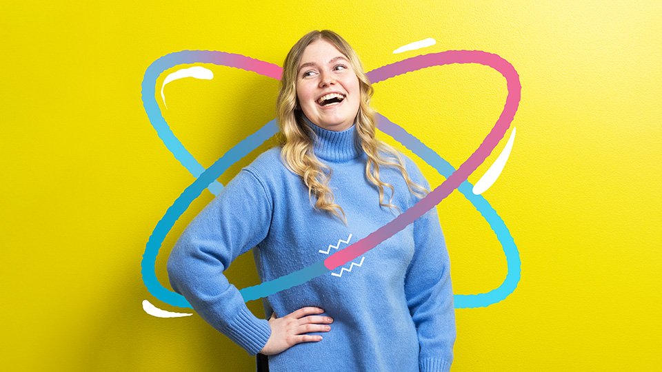 A girl in a blue blouse stands in front of a yellow background.