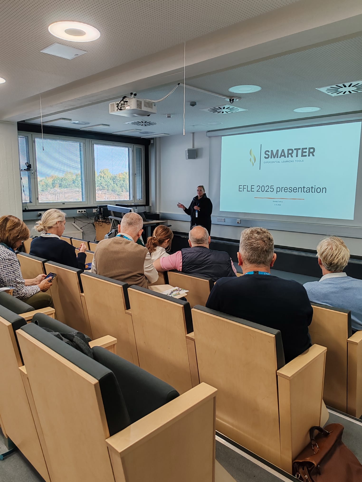 Conference participants sit in the auditorium and listen to the presentation.
