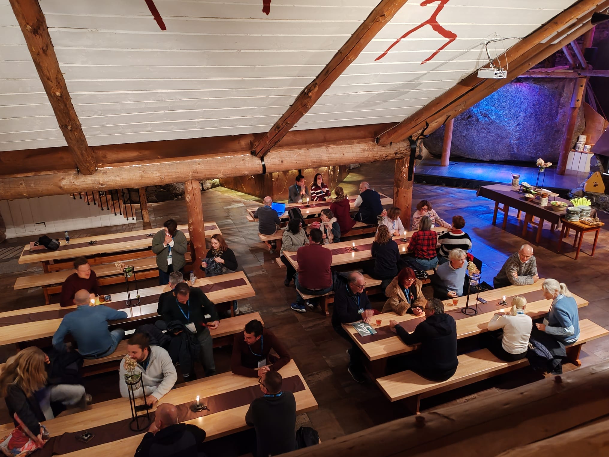 Conference participants dining in a homely setting.