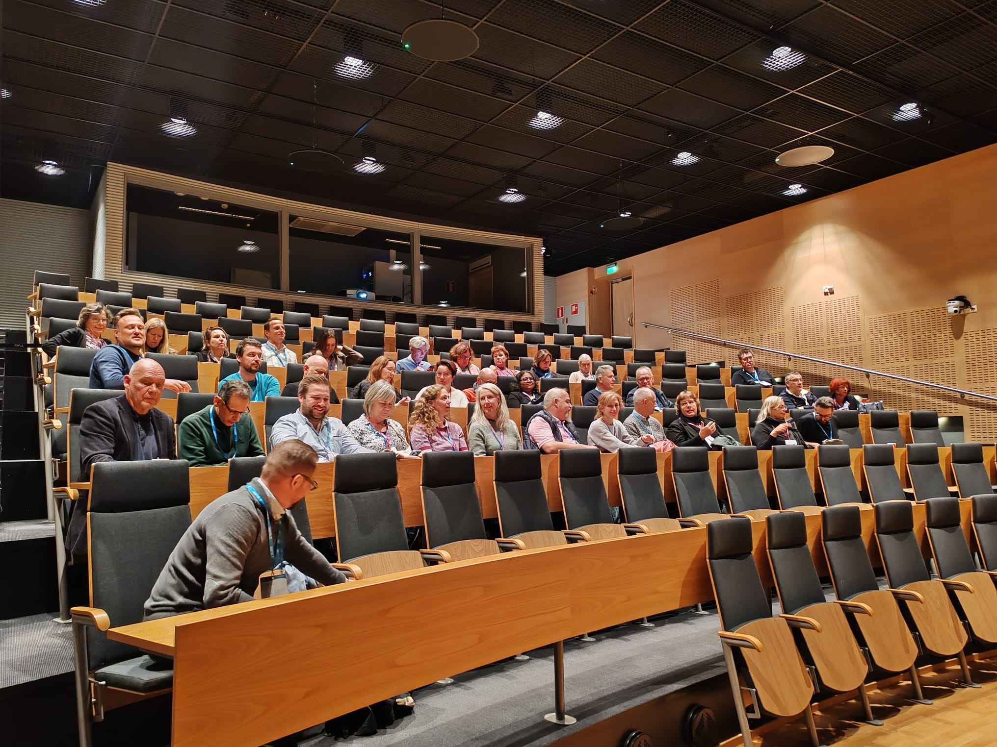 The audience sits in the auditorium.