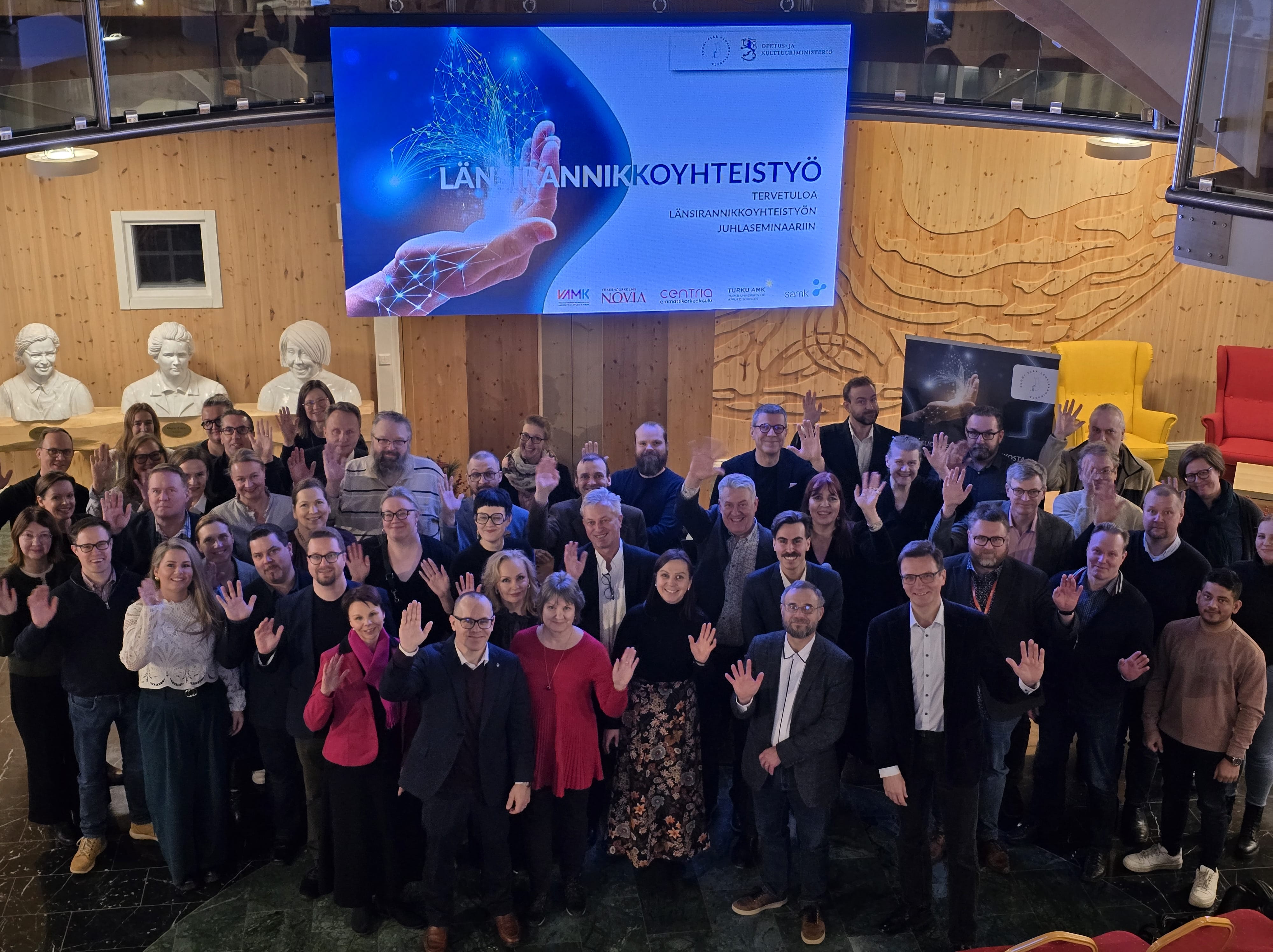 Ryhmä ihmisiä poseeraa kameralle.