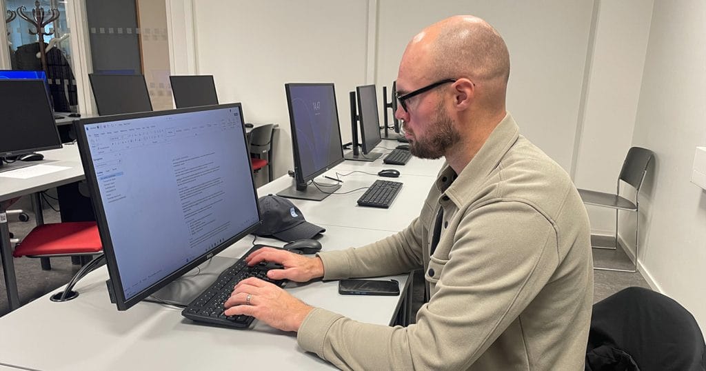 Jesse Joensuu istuu tietokoneen ääressä.