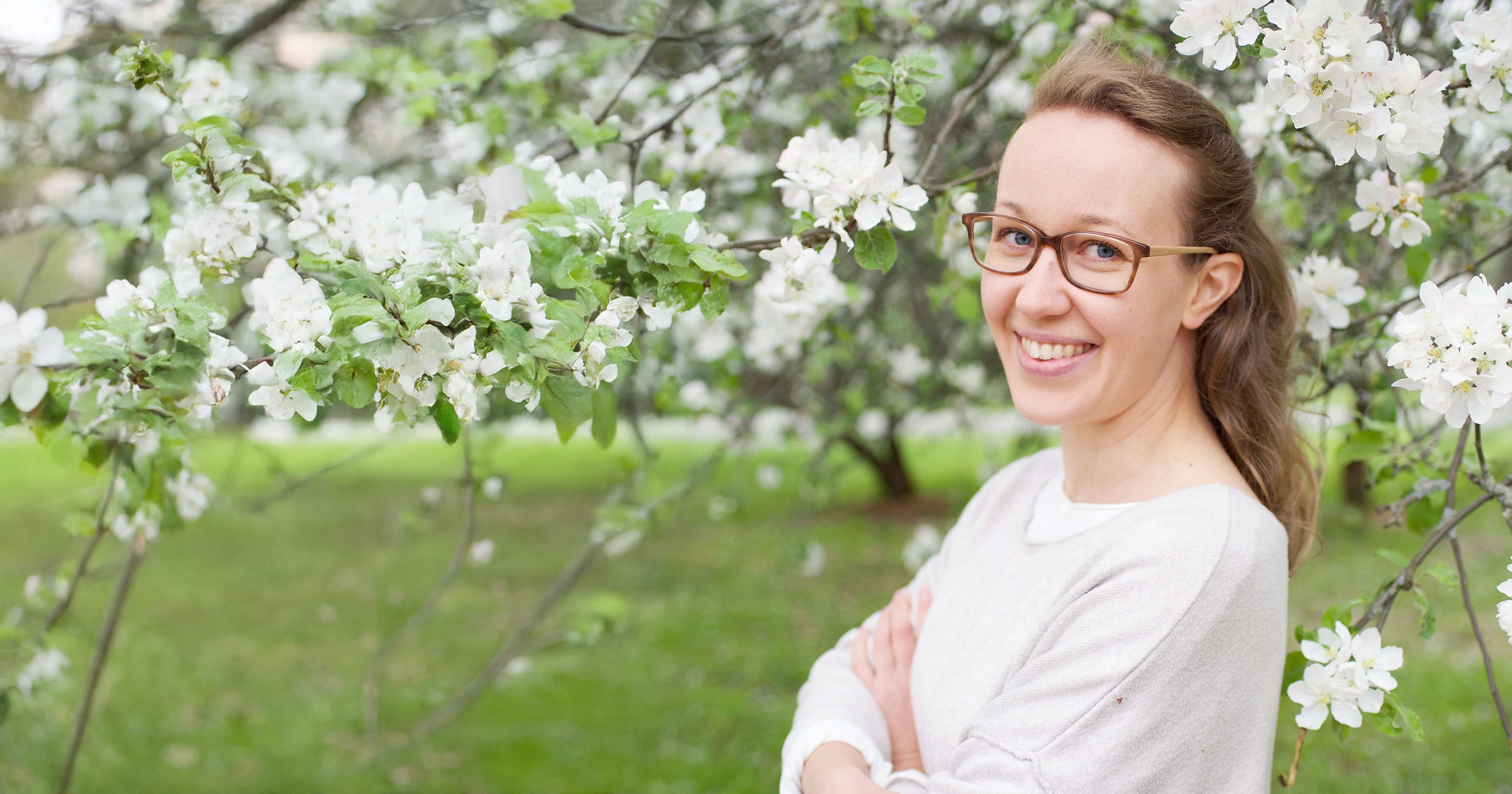 Tuuli Kilpeläinen omenapuiden alla.