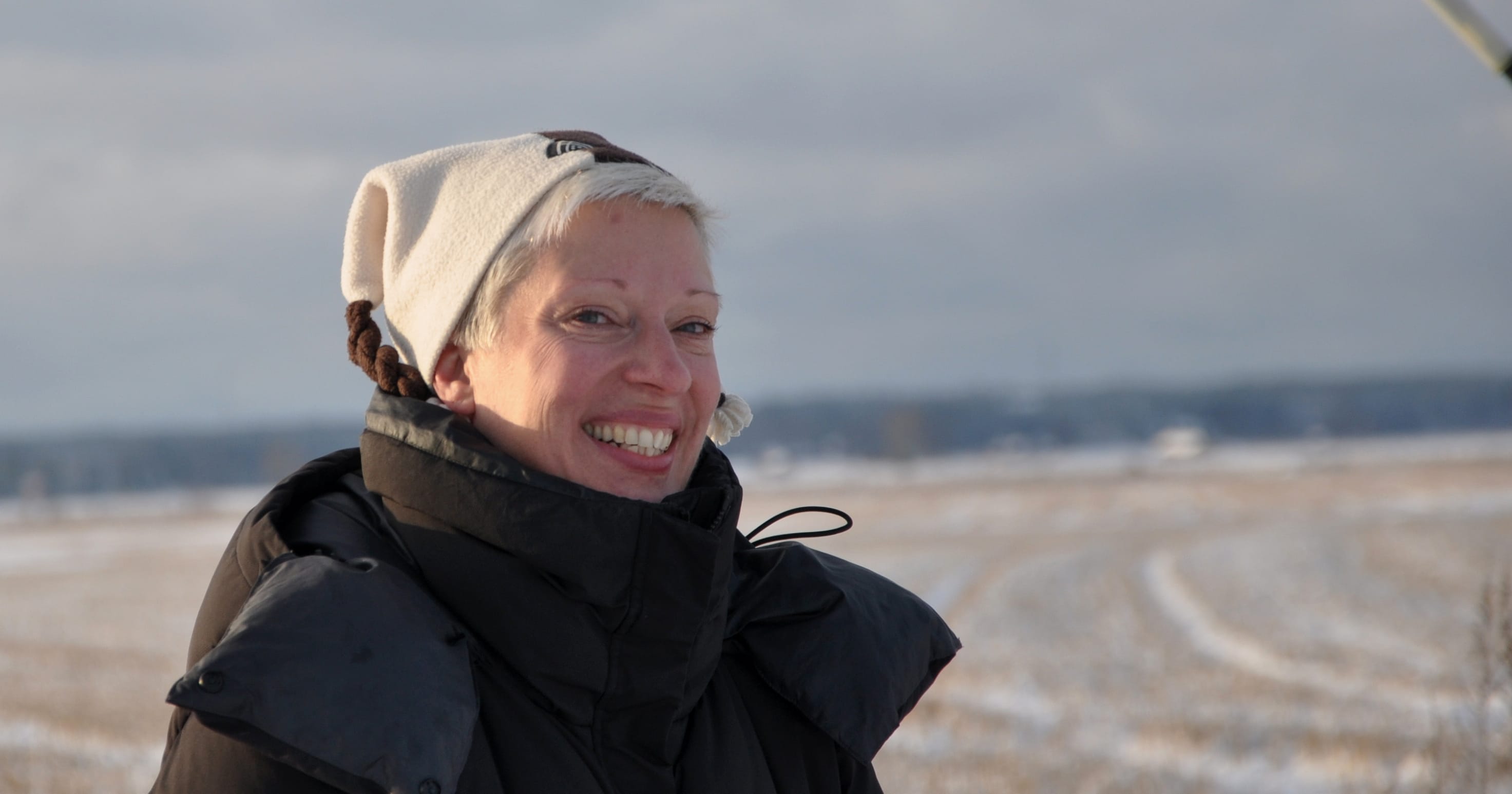 Annika Elo lähikuvassa talvisen pellon laidalla.