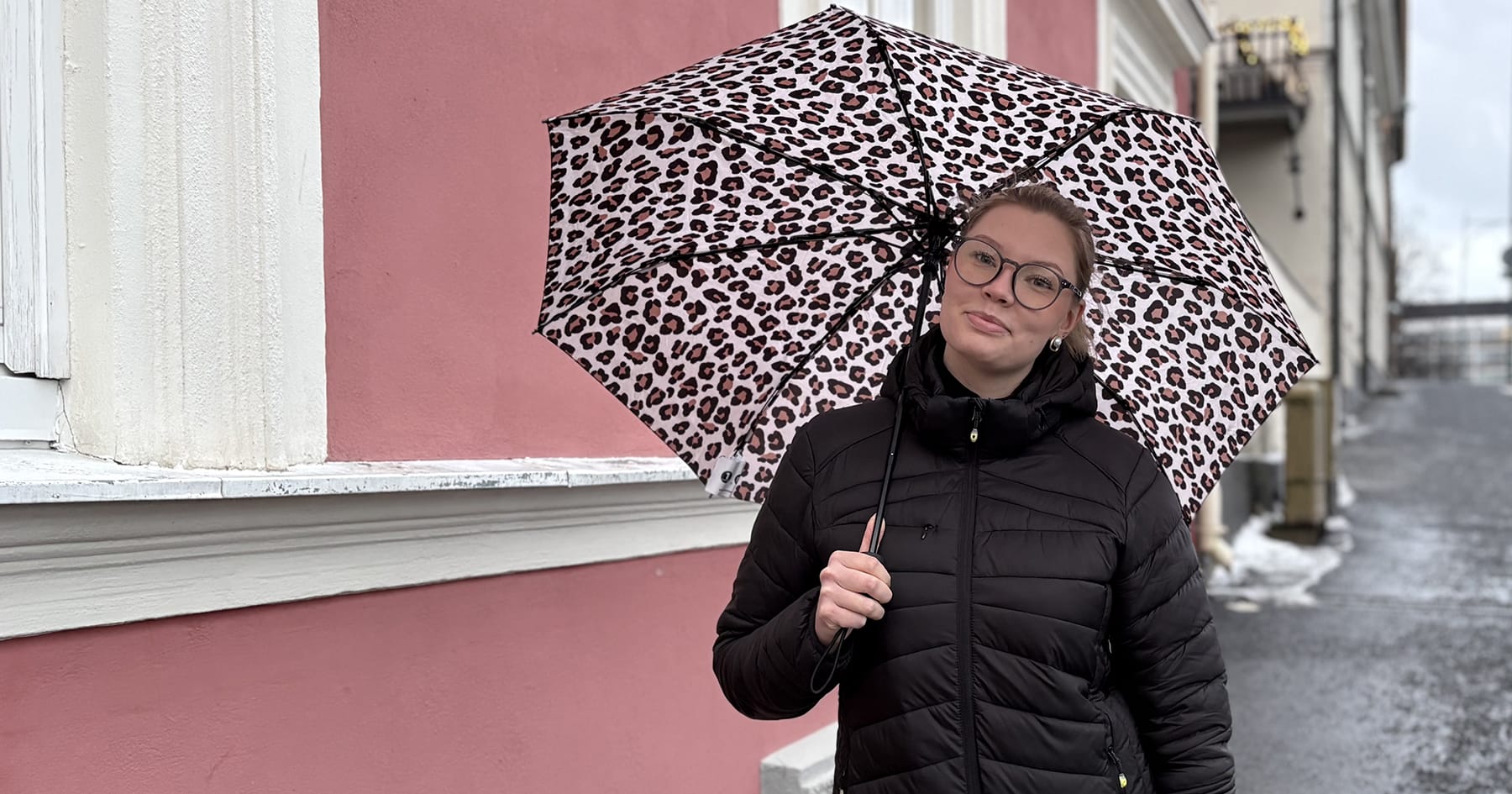 Eveliina Laine seisoo kadulla sateenvarjo kädessä.