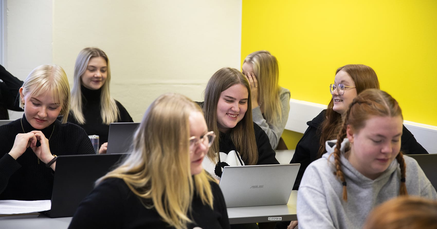 Matkailun opiskelijoita istuu luokassa.