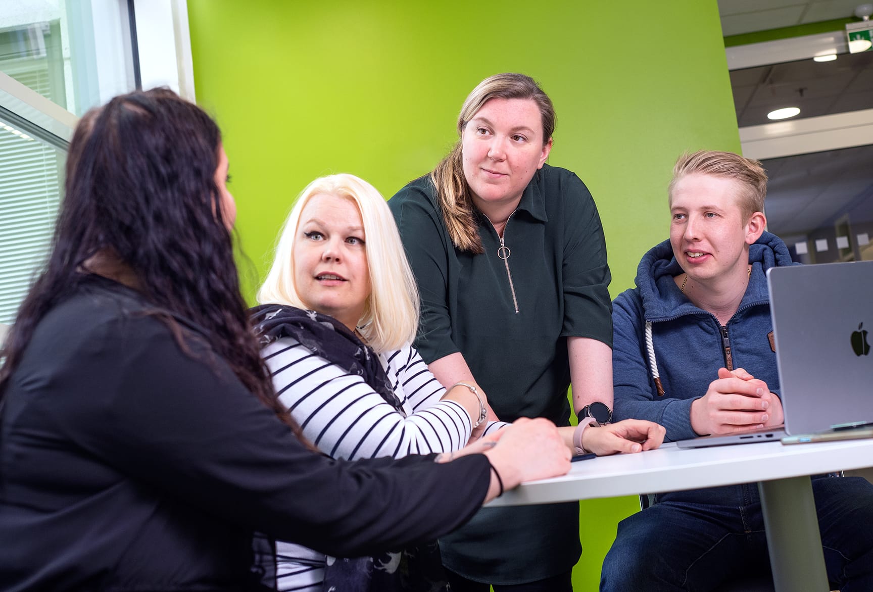 Neljä opiskelijaa tietokoneen äärellä.