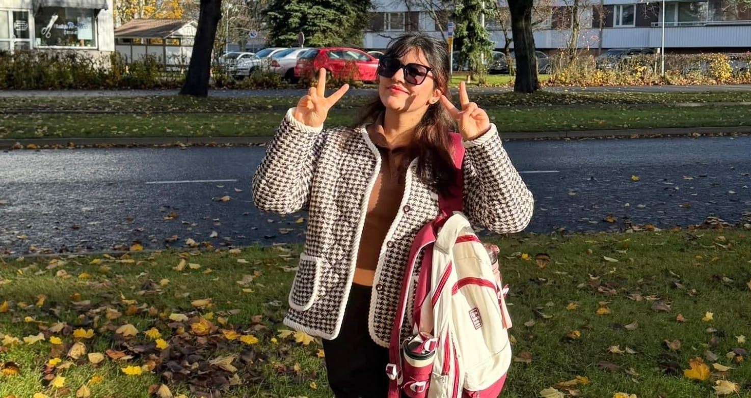 A student outdoors in the fall.