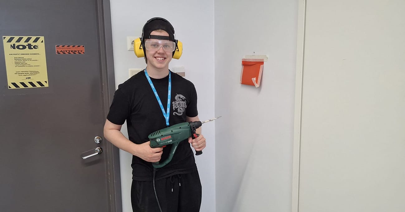 Dani Tähtinen seisoo suojavarusteissa pora kädessä.