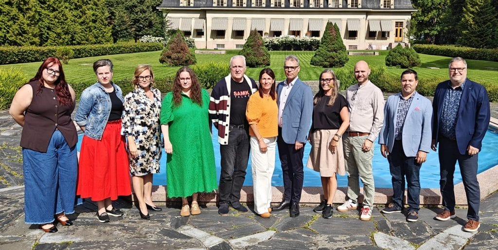 SAMK’s Board of Directors in a group photo taken outdoors in front of a building.